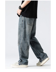 Détail du genou déchiré et texture délavée sur ce jean large pour homme en bleu rétro