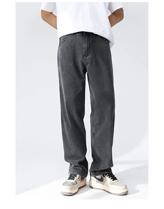 Close-up of dark grey washed denim fabric texture and straight leg cut of the trousers