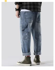 Detail view of cargo pockets and side loops on men's vintage washed blue denim carpenter pants