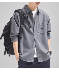 Detail of grey cotton shirt with black MOBAID letter embroidery on the chest pocket