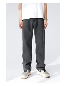 Detail of dark gray straight-leg denim jeans with loose fit and vintage wash finish