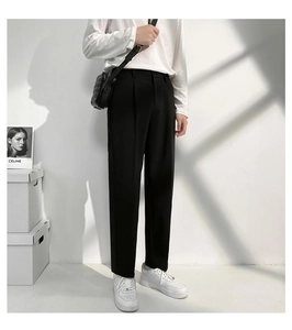 Tenue d'homme de style minimaliste avec pantalon de costume noir droit et haut blanc