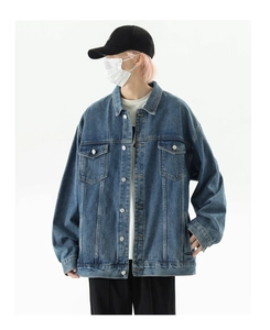 Close-up of oversized retro blue denim jacket with metal buttons and chest pockets