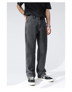 Detail of dark grey wide-leg denim jeans with vintage wash texture and straight-leg fit