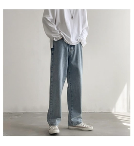 Detailweergave van de lichtblauwe gewassen jeans met wijde pijpen en een losse pasvorm