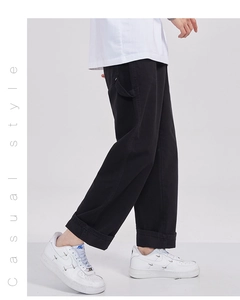 Détail d'un pantalon cargo en coton noir avec sangle latérale et revers au bas du pied