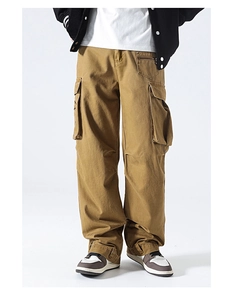 Detail view of khaki multi-pocket cargo pants with functional zippers and side flap pockets