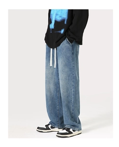 Détail d'un jean bleu clair délavé à coupe droite avec taille élastique à cordon