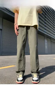 Detail view of olive green cargo pants with reinforced double-knee panels and metal rivets