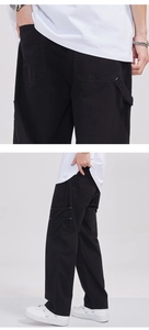 Détail d'un pantalon cargo noir à coupe droite avec poches latérales à rabat en coton dense