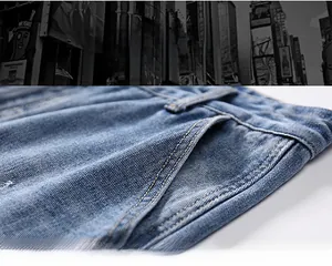 Detailed macro view of the front pocket on blue denim jeans with gold double stitching