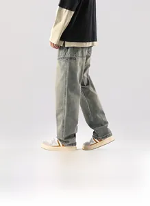 Détail du tissu denim gris-bleu délavé sur un jean homme à coupe droite et décontractée