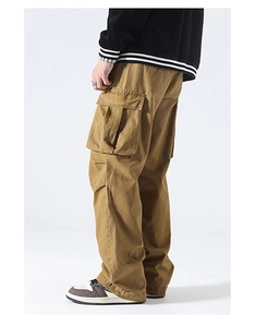 Detail view of khaki utility cargo pants featuring large side flap pockets and straight cut
