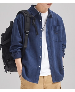 Detail of navy blue corduroy shirt featuring a chest pocket with embroidered lettering