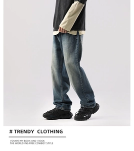 Détail d'un jean bleu délavé vintage pour homme avec jambe large et finition délavée rétro