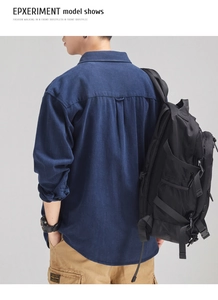 Rear view of a dark blue long-sleeve cotton shirt styled with khaki cargo trousers