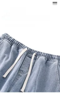 Dettaglio dei jeans lavaggio chiaro con coulisse elastica e trama in twill