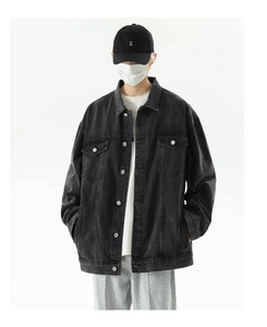 Detailed shot of heavy washed black denim jacket texture with silver metal buttons