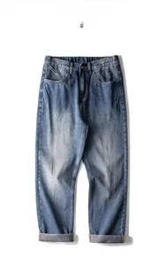 Détail d'un jean bleu délavé vintage avec moustaches et taille élastique confortable