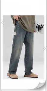 Close-up of loose fit vintage washed denim jeans with decorative leather waist patch