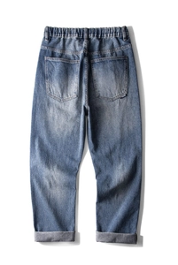 Détail arrière d'un jean bleu délavé avec taille élastique et deux poches