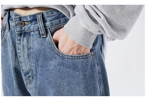 Close-up of vintage metal button and yellow contrast stitching on blue denim jeans