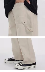 Détail du pantalon cargo beige avec poches arrière renforcées et ourlet droit élégant