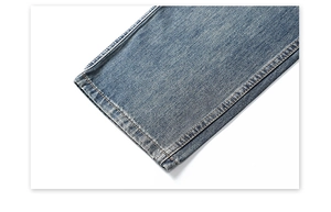 Gros plan du denim bleu délavé vintage avec ourlet à double couture et texture sergée