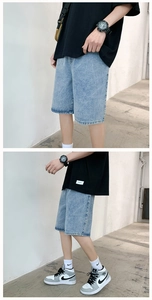 Detail view of light blue loose denim shorts featuring washed texture and elastic waist