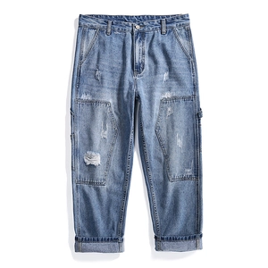 Men's light blue straight-leg denim jeans with patchwork details and distressed finish