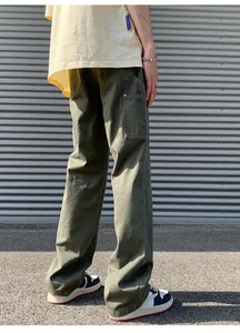 Detail view of military green cotton cargo pants with large side pockets and metal rivets