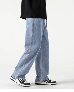Dettaglio dei jeans larghi azzurri con coulisse in vita e cuciture a contrasto