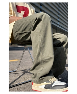 Detail view of olive green cargo pants showing side patch pockets and durable canvas texture