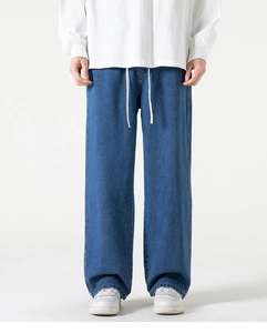 Dettaglio di jeans blu larghi da uomo con coulisse in vita e taglio a gamba larga