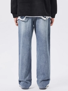 Men's light blue baggy jeans with vintage wash and straight leg cut on a white background