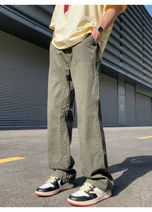 Outdoor shot of men's olive green wide-leg carpenter pants with double-knee panels