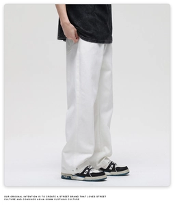 Detail view of white wide-leg cotton jeans showing side silhouette and drape in street style