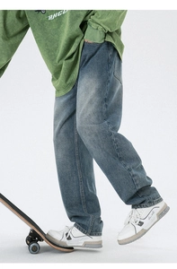 Détail d'un jean droit en denim avec délavage vintage et esthétique de style urbain