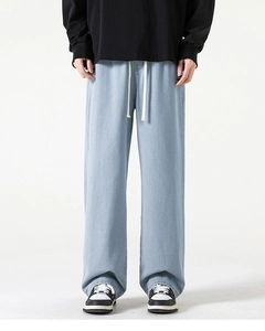 Dettaglio di jeans a gamba larga celeste con coulisse in vita e texture denim