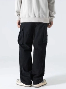 Back view of men's black high-street cargo pants with multiple pockets and wide-leg cut