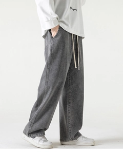 Dettaglio dei pantaloni grigi lavati a gamba larga con coulisse elastica e taglio dritto