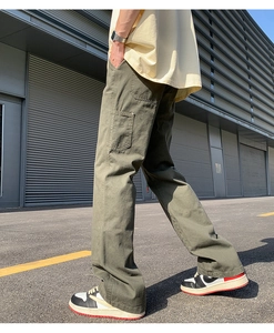 Outdoor street shot of olive green cargo pants with straight-leg cut and utility pockets