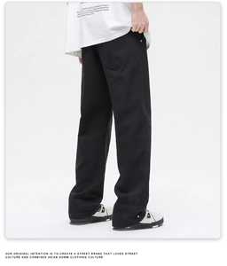 Rear view of black loose-fit streetwear trousers with back pockets and stacking hem