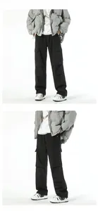 Detail of black tactical cargo pants featuring large side flap pockets and straight-leg fit