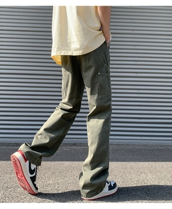 Detail view of military green cotton cargo pants with loose straight fit and large back pockets