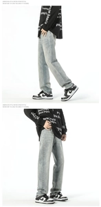 Detail of light blue washed denim jeans for men featuring a relaxed straight leg fit