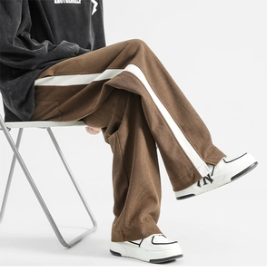 Detail of brown corduroy trousers with contrasting white side stripe and high texture