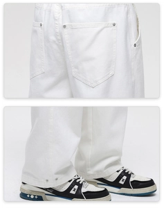 Detail view of white cotton denim jeans showing back pocket rivets and buttoned hem finish