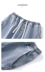 Dettaglio di jeans lavati azzurro chiaro con elastico in vita e coulisse in cotone bianco