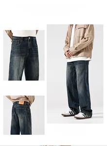 Detail view of slim fit dark blue denim jeans showing vintage wash and leather brand patch